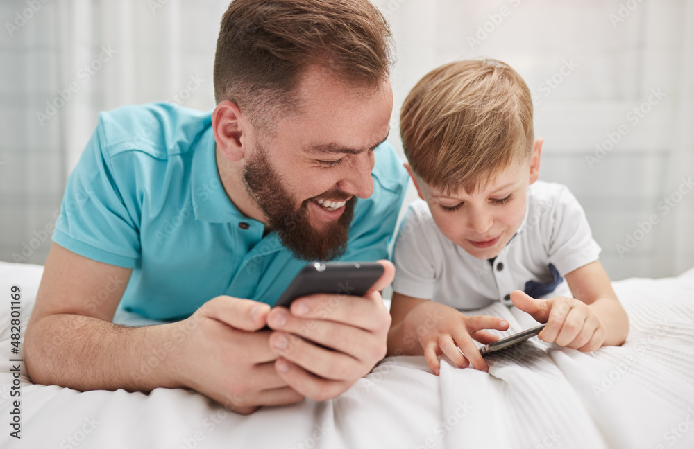 Father and son using smartphones together Father and son using smartphones together