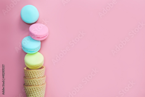 Macaroons on colored pink background, composition of colorful french cookies macarons Gift for Valentine's Day Mothers Day top view copy space