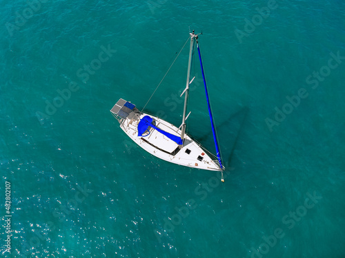 Foto Aerial wonderful view of a enormous white and blue yacht sailing across the blue