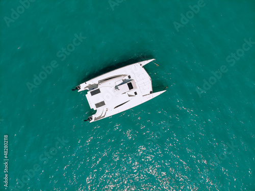 Picturesque top view of a huge white catamaran sailing across the deep sea. Aerial view. © Semachkovsky 