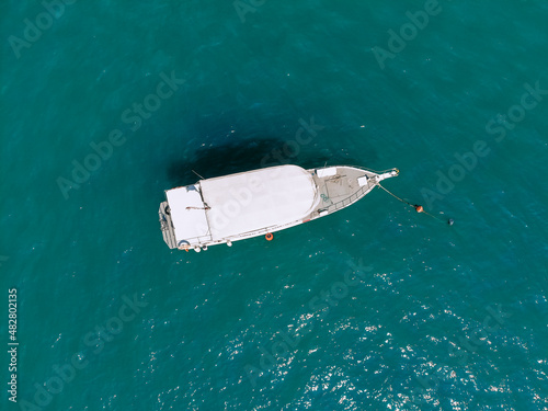 Huge white yacht is sailing alone across the deep blue sea, top view