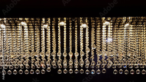many tiny spherical clear glass beads threaded in strings each identically designed to make a full complete curtain photo