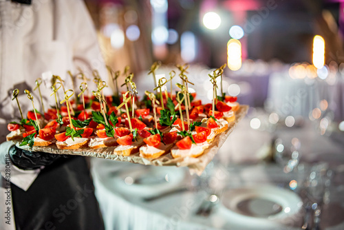 waiter holds tray with canape. Restaurant service. buffet or catering. photo