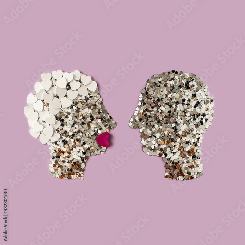 Man and woman silhouette made with hearts. People in love.  Valentines, couple, or Mother's day concept against pink background.