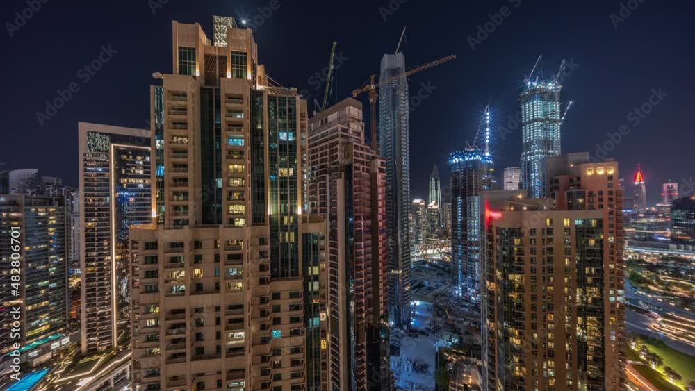 Aerial cityscape night timelapse with illuminated architecture of Dubai downtown.
