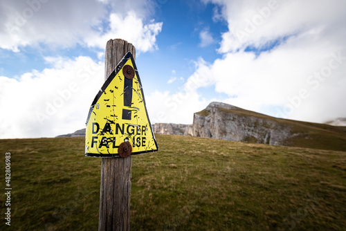 vieux panneau de danger tordu et jaune à la montagne