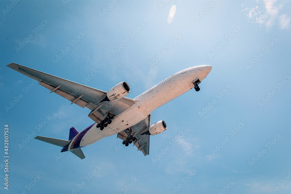 Obraz premium Commercial airplane is flying above clouds. Fast travel around the world. View from below.