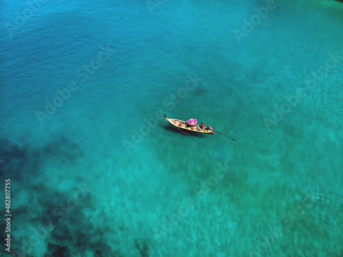 A lonely boat is floating peacefully in the middle of a vast blue ocean, aerial view © Semachkovsky 