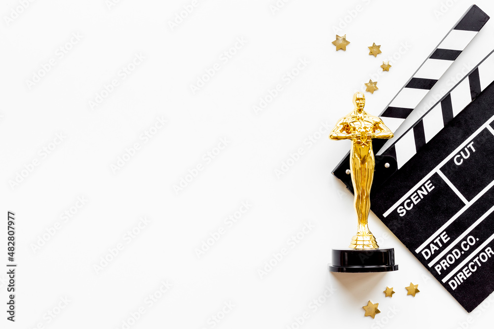 Movie clapper board with golden film award statue Movie clapper board with golden film award statue