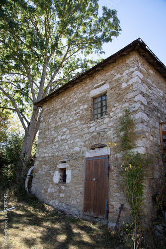 vieille maison avec mur en pierre et un arbre