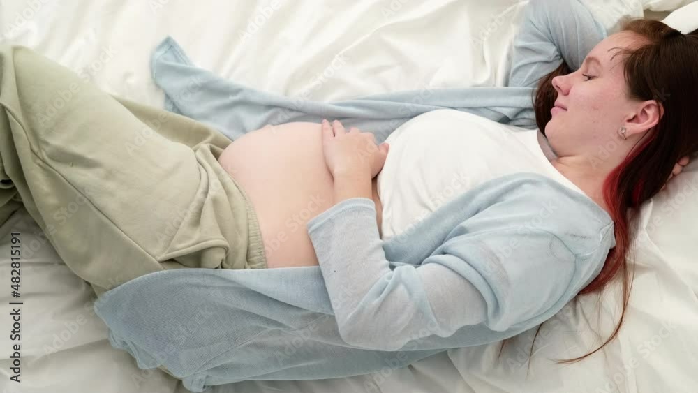 Top view Pregnant expectant mother caressing her belly. Woman hands touching her tummy, waiting child, lying on bed Preparation for childbirth, Girl big belly advanced pregnancy. Top view Pregnant expectant mother caressing her belly. Woman hands touching her tummy, waiting child, lying on bed Preparation for childbirth, Girl big belly advanced pregnancy.