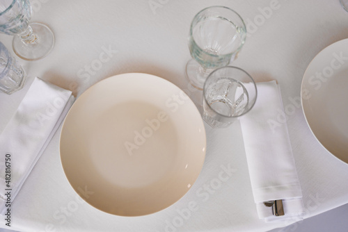 view from above. an empty white plate and glasses on the table. 