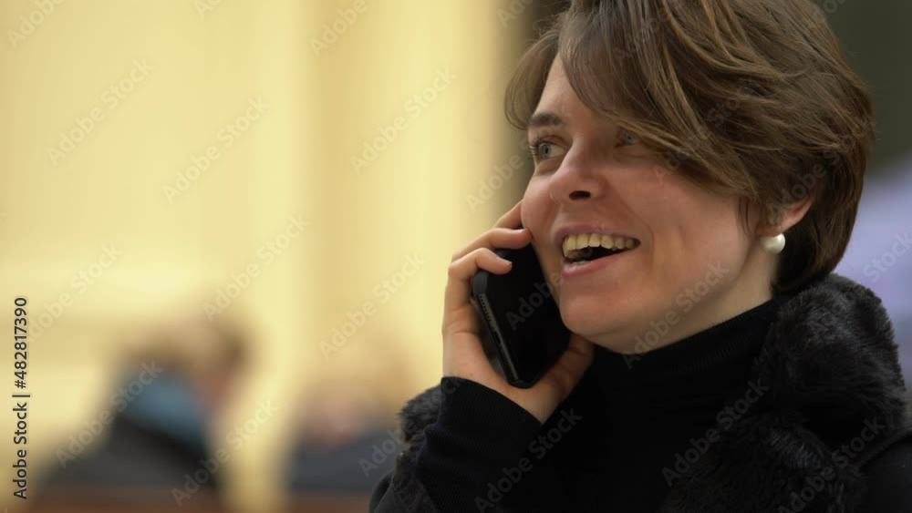 Smiling attractive blonde woman talks on the phone with a friend of hers. Technology, communication concept Smiling attractive blonde woman talks on the phone with a friend of hers. Technology, communication concept