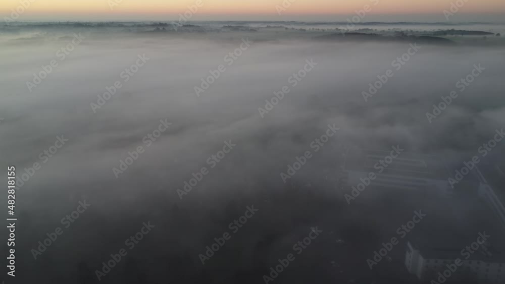 Foggy aerial view of sunset with obscure buildings and traffic below Foggy aerial view of sunset with obscure buildings and traffic below