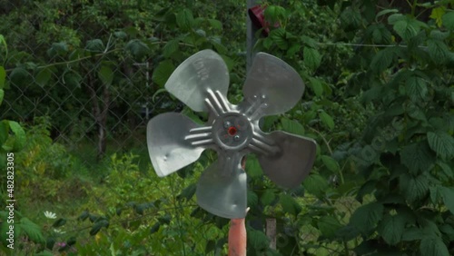 Homemade fan in the green garden at the cottage. The invention scares moles.