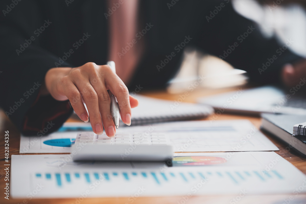 business woman or accountant who are using a calculator to calculate business data Accounting documents and laptop computer at the office business idea business woman or accountant who are using a calculator to calculate business data Accounting documents and laptop computer at the office business idea