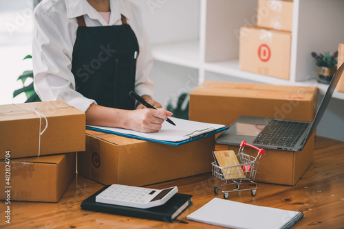 Small start-up business owners checking parcels at work, freelancers, salespeople, checking production orders. Pack products for delivery to customers Sell ​​Ecommerce Shipping Ideas © Daenin