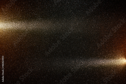 Two oncoming wide beams of light on a black background in white grain