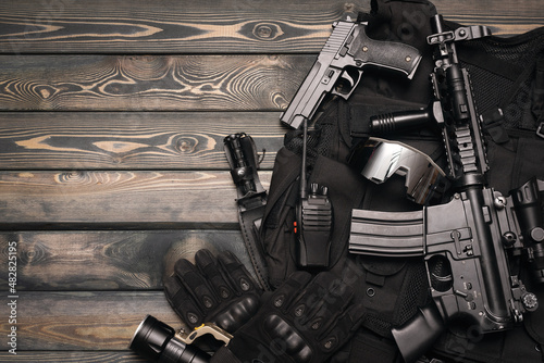 Airsoft weapons and equipment on the wooden flat lay background with copy space. photo