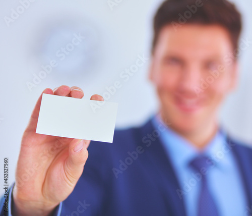 Portrait of young man holding blank white card