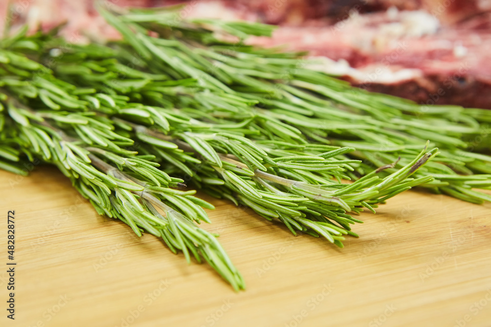 Herb spice rosemary lies on a wooden background. Seasonings for the kitchen and cooking. Herb spice rosemary lies on a wooden background. Seasonings for the kitchen and cooking.