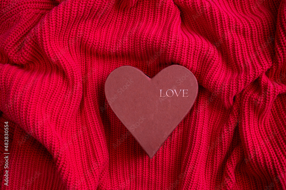 Top view of Red heart with LOVE word  on knitted texture background. Valentines day celebration or love concept.