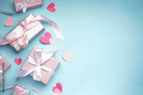 Gift boxes for Valentine's Day and confetti on blue background, space for text. Flat lay.