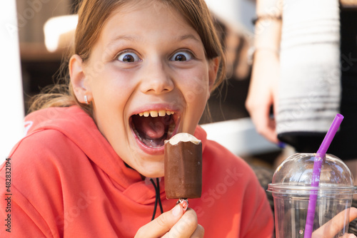 Happy little girl have fun with an ice cream  close-up