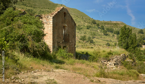 Rural ruined house in the green spring countryside.