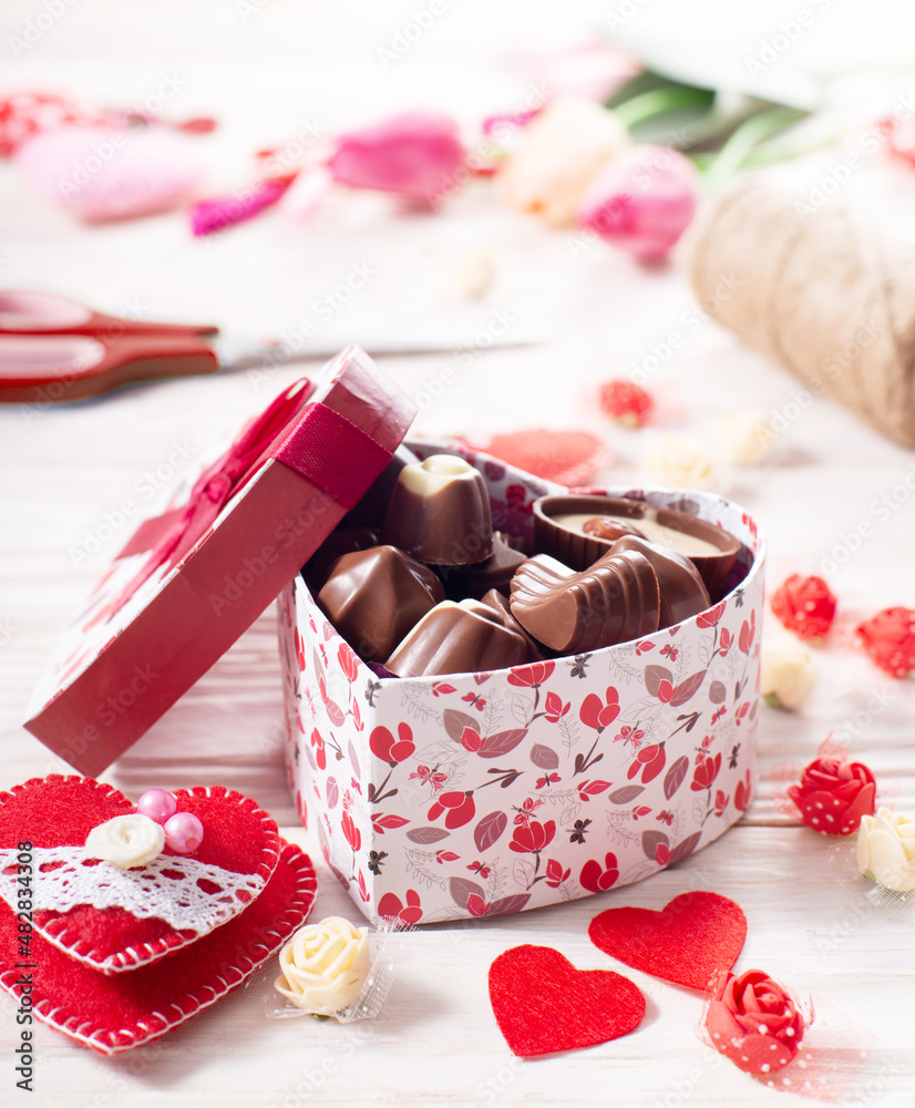 Chokolate box in shape of heart on white wooden table valentine background low angle view Chokolate box in shape of heart on white wooden table valentine background low angle view