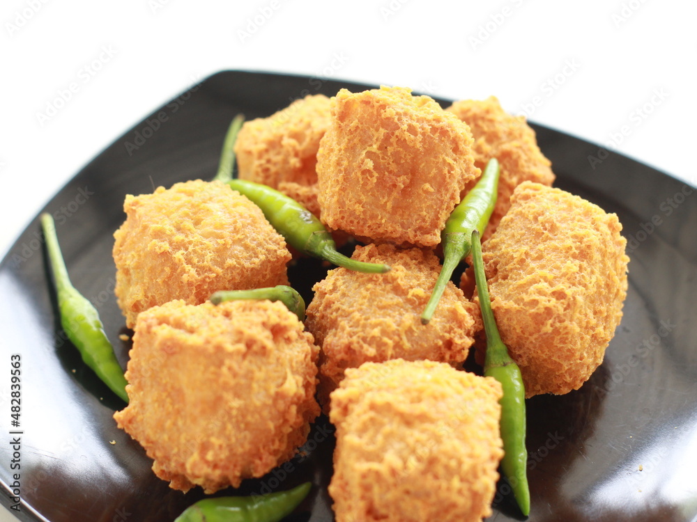Photo of crispy tofu and green chili on a black plate Photo of crispy tofu and green chili on a black plate