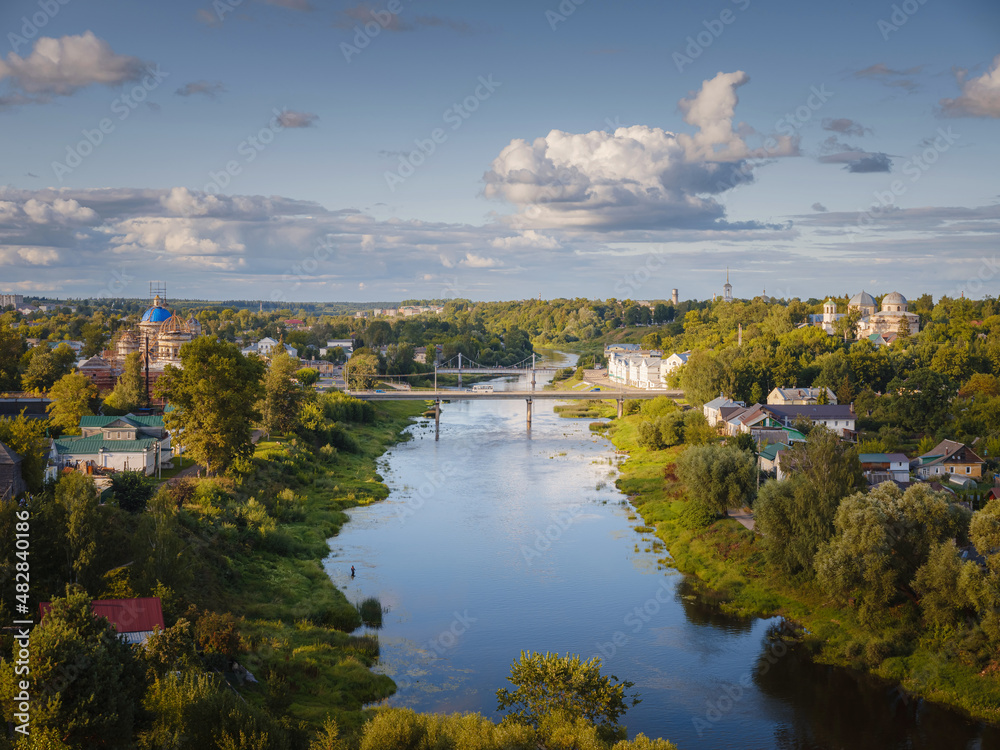 summer travel to Russia, Torzhok city, Tver region. View on old buildings at the embankment from the bridge across the Tvertsa river. Rural landscape