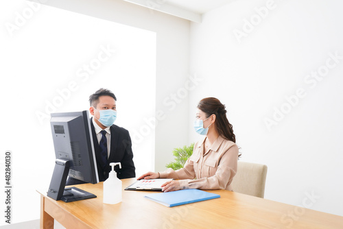 感染症対策をしてオフィスで働くビジネスパーソン © maroke
