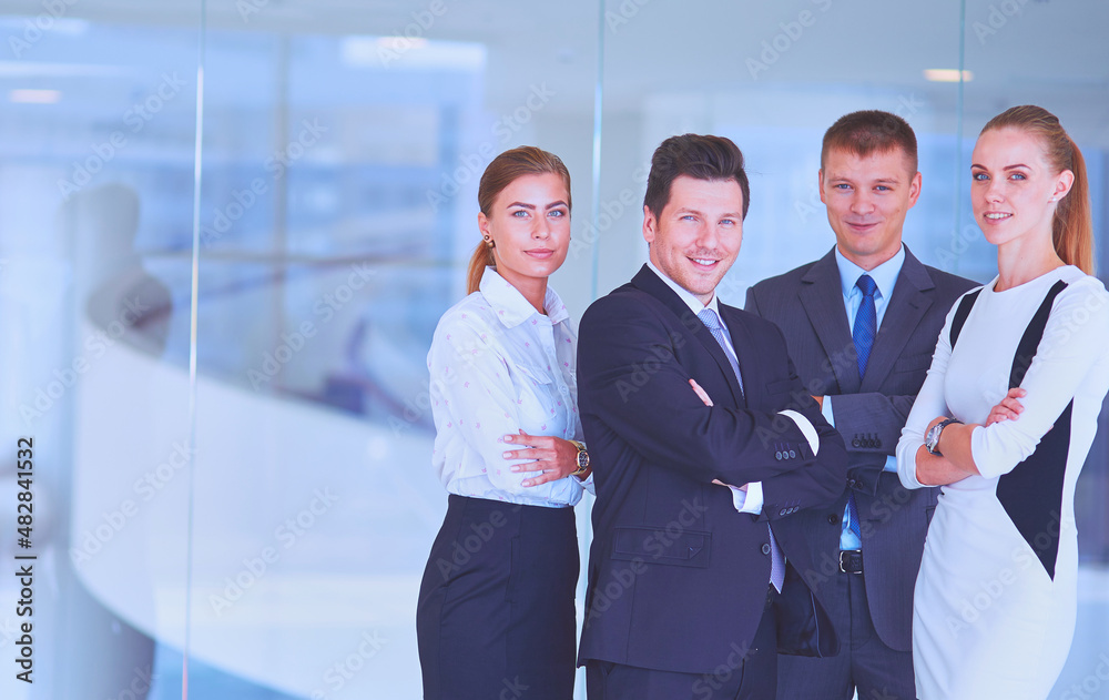 Smiling successful business team standing in office Smiling successful business team standing in office