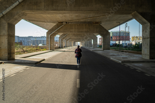 Chica en medio de una carretera despejada andando por el centro