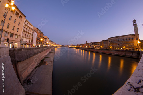 Italy Tuscany Pisa along the Arno River at sunset, street lamps lit on the promenade