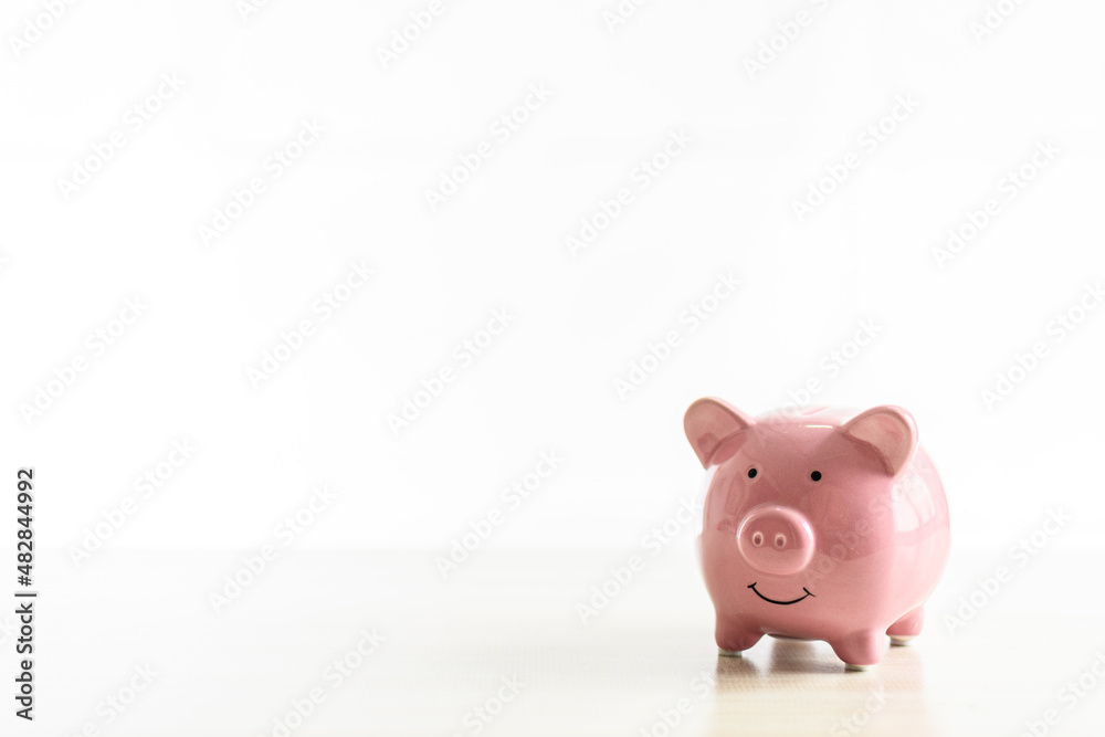 Piggybank of pink pigs placed on a wooden table. The concept for Finance, Banking, Savings, Investing, Marketing, Close up. Copy space on left for design or text. Nobody and white background Piggybank of pink pigs placed on a wooden table. The concept for Finance, Banking, Savings, Investing, Marketing, Close up. Copy space on left for design or text. Nobody and white background