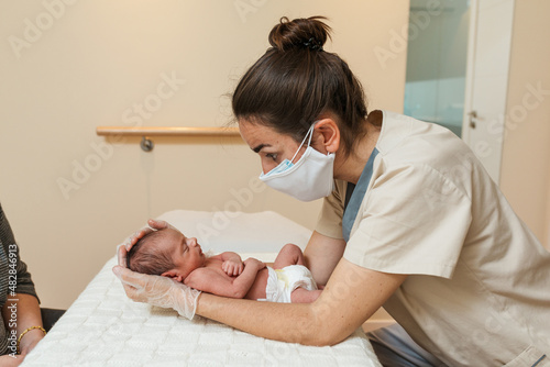 Professional physiotherapist doing parietal work and lambdoid suture in a newborn baby. photo