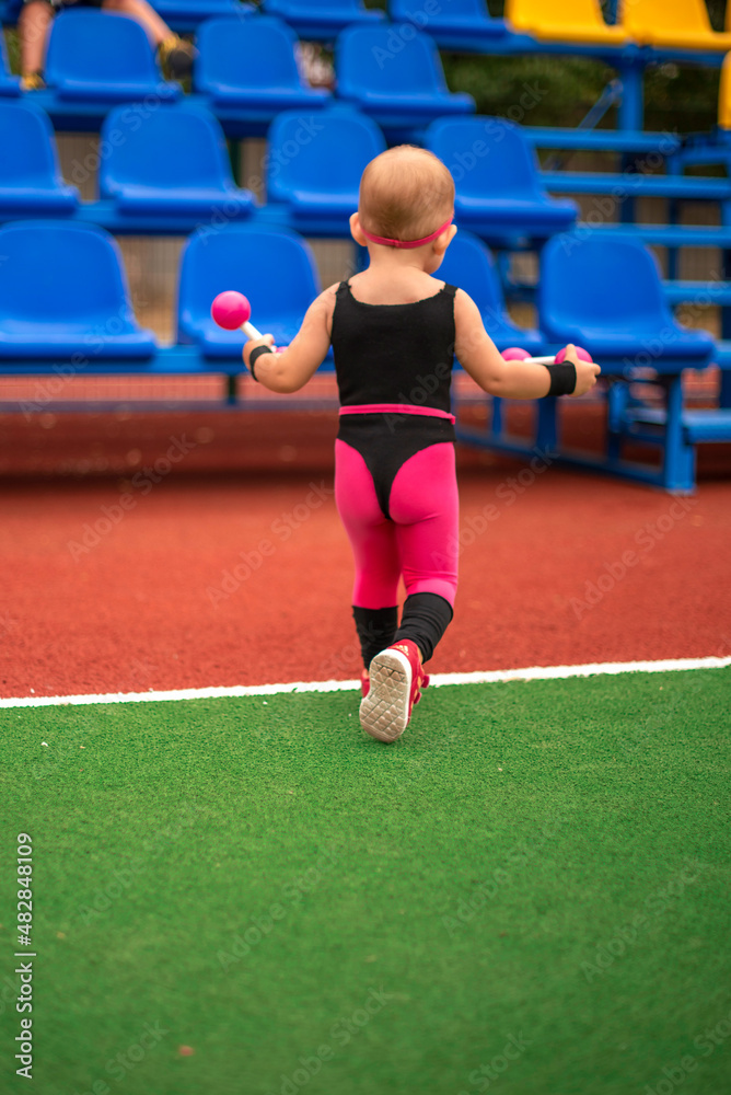 Obraz premium girl child in sportswear on the sports ground