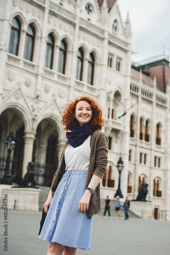 Young redhead Caucasian woman near Parliament Building, Budapest, Hungary