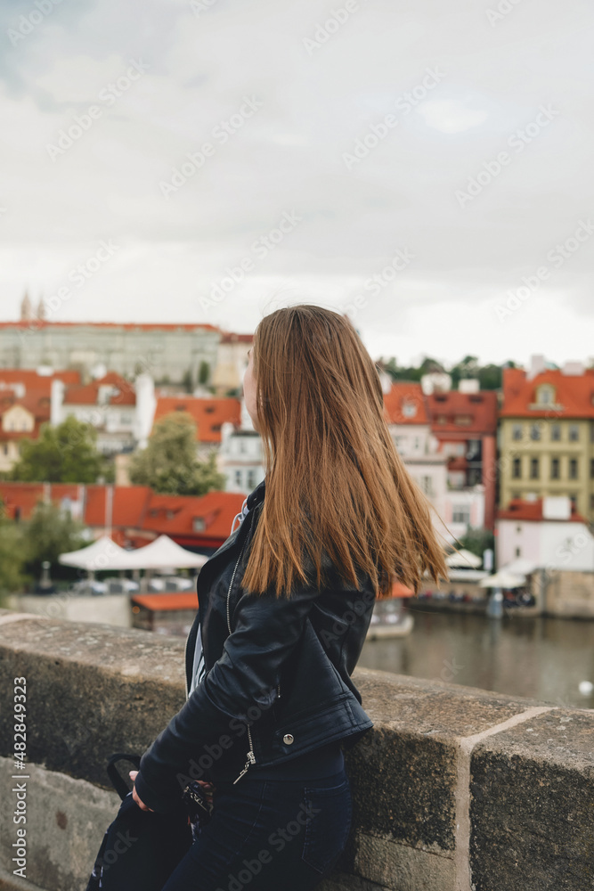 Fototapeta premium Woman on view point with amazing view. Cute female tourist in Prague, Czech republic.