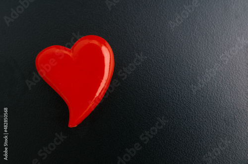Red heart on black wooden background. Valentines day card