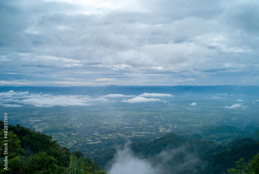 Green field with cloud sky and mountains