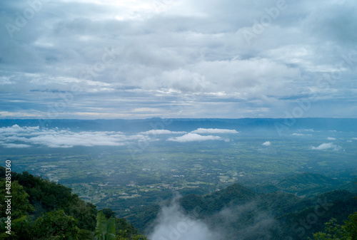 Green field with cloud sky and mountains