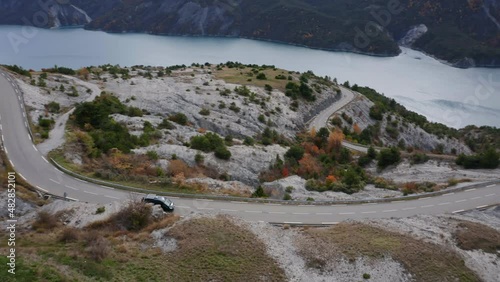Aerial View of Camper Van driving along lake Lac de Serre-Poncon, France