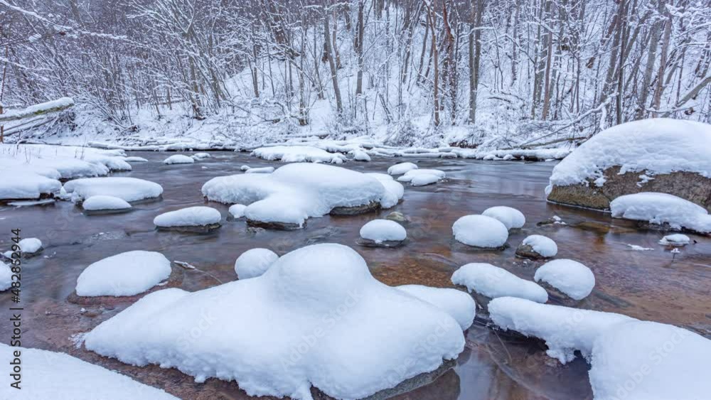 The wild frozen river in the winter wood atfter snow storm, the wild nature, ice, snow-covered stones, peace and quiet, 4k slider timelapse The wild frozen river in the winter wood atfter snow storm, the wild nature, ice, snow-covered stones, peace and quiet, 4k slider timelapse
