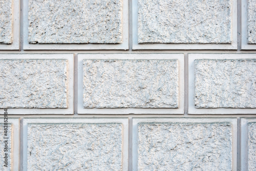 Fototapeta premium Imitation of a wall made of gray rough stone. Masonry of blocks. Decorative plaster. For background or texture