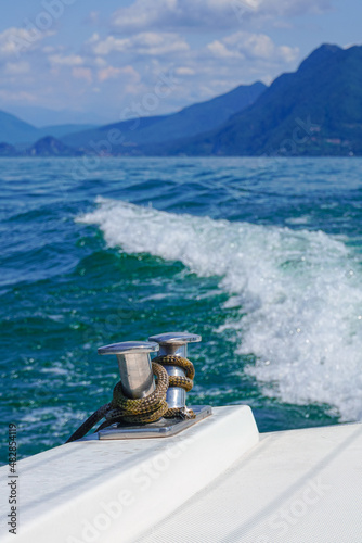 The back of the yacht against the background of waves, mountains, and the brightly colored sea