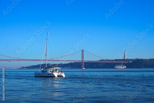 White yacht against the background of the underwater bridge in Lisbon, Portugal