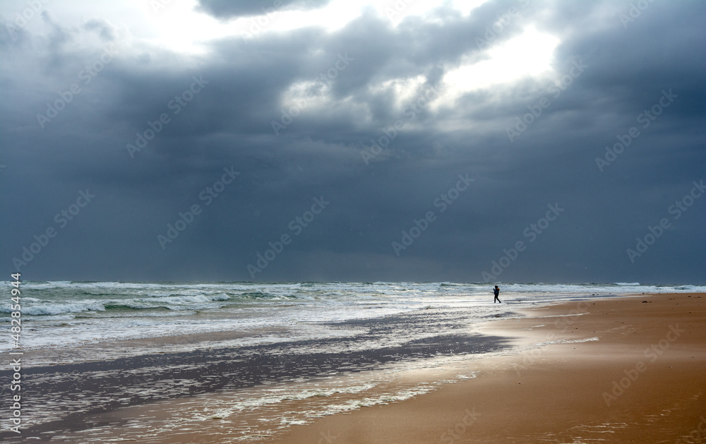 Rattray Head Lighthouse Beach- Golden Sandy Dunes and Stormy Sea state - Single person walks along a deserted beach with dramatic stormy skies